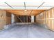 Clean detached garage with concrete floor, exposed ceiling beams, and white door at 8780 E Yale Ave, Denver, CO 80231