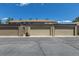 Row of detached condo garages on cracked pavement under a blue sky at 8780 E Yale Ave, Denver, CO 80231