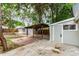 Spacious backyard with a covered patio area, storage shed, and mature trees at 725 Knox Ct, Denver, CO 80204