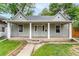 Charming single-story home featuring a covered front porch with column supports and well-maintained landscaping at 725 Knox Ct, Denver, CO 80204