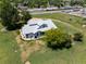 An aerial view of a home on a large lot surrounded by mature trees and open spaces at 5602 County Road 15, Fort Lupton, CO 80621
