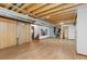 Spacious basement area with unfinished ceiling, wood-look floors, and multiple access doors at 5602 County Road 15, Fort Lupton, CO 80621