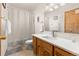 Bathroom with wood cabinet, large mirror, and tiled floors, offering a practical design at 5602 County Road 15, Fort Lupton, CO 80621