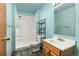 Bathroom featuring a shower with white tile, a vanity with white top, and blue colored walls at 5602 County Road 15, Fort Lupton, CO 80621