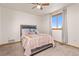 Cozy bedroom with neutral walls, carpet, ceiling fan and large window allowing for natural light at 5602 County Road 15, Fort Lupton, CO 80621