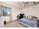 Bedroom with a large window, a ceiling fan, and an organized desk setup for work or leisure at 5602 County Road 15, Fort Lupton, CO 80621