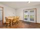 Bright dining area with hardwood floors, a wooden table with chairs, and access to the backyard at 5602 County Road 15, Fort Lupton, CO 80621