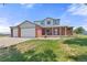 Charming two-story home with a three car garage, brick facade, and a well-manicured lawn at 5602 County Road 15, Fort Lupton, CO 80621