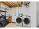 Functional laundry room featuring a side-by-side washer and dryer with open storage and utility sink at 5602 County Road 15, Fort Lupton, CO 80621