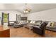Spacious living room featuring a large gray couch, wood floors, a ceiling fan, and a fireplace at 5602 County Road 15, Fort Lupton, CO 80621