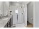 Bright bathroom with walk-in shower with glass enclosure, granite countertop, and a toilet at 5110 E 64Th Ave, Commerce City, CO 80022