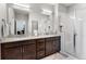 Bright bathroom featuring double sinks, granite countertops, and a glass shower enclosure at 5110 E 64 Ave, Commerce City, CO 80022