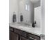 Charming bathroom with dark wood cabinets, granite countertops, and a large mirror at 5110 E 64Th Ave, Commerce City, CO 80022