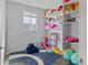 Bright bedroom with shelves stocked with stuffed animals and toys and a blue patterned rug at 5110 E 64 Ave, Commerce City, CO 80022