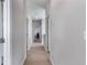 Hallway with carpet flooring, gray walls, white trim, and multiple doorways at 5110 E 64Th Ave, Commerce City, CO 80022