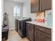 Functional laundry room with modern appliances, cabinets, and ample counter space at 5110 E 64Th Ave, Commerce City, CO 80022