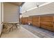 View of a patio with pavers, a small outdoor table and chairs, surrounded by wooden fencing at 5110 E 64Th Ave, Commerce City, CO 80022