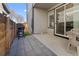 View of a patio with grey pavers, barbeque, fence, and glass sliding door at 5110 E 64 Ave, Commerce City, CO 80022