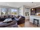 Bright living room with sectional sofa, large windows offering natural light, and modern design at 5110 E 64Th Ave, Commerce City, CO 80022