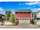 Two-story detached garage with green roof, red stucco exterior, and white carriage door at 11776 Perry St, Westminster, CO 80031