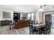 Bright dining room with a dark wood table and chairs, adjacent to a living room with fireplace at 3851 Stonebrush Dr # 11B, Littleton, CO 80126
