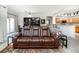 Spacious living room with a brown leather sectional sofa, and views into the kitchen and dining areas at 3851 Stonebrush Dr # 11B, Littleton, CO 80126