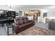 Open living area features a brown leather reclining sofa, and a view into the kitchen and dining area at 3851 Stonebrush Dr # 11B, Littleton, CO 80126