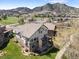 Aerial view of a charming home, golf course, a pond, and the mountains in the background at 16223 River Haven Way, Morrison, CO 80465