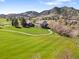Breathtaking aerial view of the real estate and surrounding golf course with mountain views in the background at 16223 River Haven Way, Morrison, CO 80465