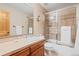 Full bathroom with a shower-tub combination with glass doors, a tile surround and a single vanity at 16223 River Haven Way, Morrison, CO 80465