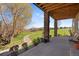 Covered patio showing stone pillars, a wood ceiling and a scenic view overlooking the golf course at 16223 River Haven Way, Morrison, CO 80465