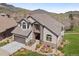 Beautiful home with a tile roof, a two-car garage, well-manicured landscaping, and scenic mountain views at 16223 River Haven Way, Morrison, CO 80465