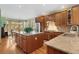 Open kitchen features granite countertops, stainless steel appliances, and a large center island with ample storage and natural light at 16223 River Haven Way, Morrison, CO 80465