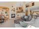 Bright living room features a cozy fireplace, plush seating, and an open layout with elegant staircase and upper-level views at 16223 River Haven Way, Morrison, CO 80465