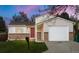 Charming home featuring a brick facade, a red front door, and an attached garage at 17753 E Nassau Pl, Aurora, CO 80013