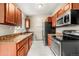 Modern kitchen featuring wooden cabinets and stainless steel appliances at 17753 E Nassau Pl, Aurora, CO 80013