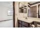Bathroom with vanity and decorative wallpaper, with a view to an adjacent bedroom at 6670 W 84Th Cir # 99, Arvada, CO 80003