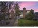 Inviting townhome featuring a brick chimney, complemented by a well-manicured lawn and mature trees at 6670 W 84Th Cir # 99, Arvada, CO 80003