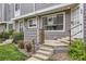 Front exterior of a gray sided townhome with concrete steps and metal railings and minimal front yard landscaping at 6670 W 84Th Cir # 99, Arvada, CO 80003