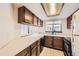 Kitchen with wood cabinets, white countertops and view into the living room at 6670 W 84Th Cir # 99, Arvada, CO 80003