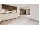 Open floor plan with living room and kitchen featuring carpet and hardwood stair case at 6670 W 84Th Cir # 99, Arvada, CO 80003