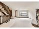 Living room featuring carpet, stone fireplace, a stairway with wood railings, and large front window providing natural light at 6670 W 84Th Cir # 99, Arvada, CO 80003