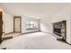 Living room featuring carpet, stone fireplace, a front door, and large front window providing natural light at 6670 W 84Th Cir # 99, Arvada, CO 80003