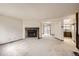 Spacious living room with carpet flooring, a stone fireplace, and openings to the kitchen and back patio at 6670 W 84Th Cir # 99, Arvada, CO 80003