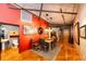 Modern dining room featuring hardwood floors, a red accent wall, and track lighting at 1863 Wazee St # 4B, Denver, CO 80202