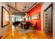 Modern dining room featuring hardwood floors, a red accent wall, and track lighting at 1863 Wazee St # 4B, Denver, CO 80202