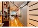 Hallway with hardwood floors, built-in shelving, concrete ceiling and a glimpse into the living area at 1863 Wazee St # 4B, Denver, CO 80202