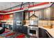 A modern kitchen features stainless steel appliances, dark wood cabinets, and a red accent wall at 1863 Wazee St # 4B, Denver, CO 80202
