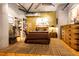 A cozy main bedroom with wood floors, concrete ceiling, exposed air ducts, and in-unit laundry at 1863 Wazee St # 4B, Denver, CO 80202