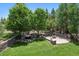 The lush backyard showcases a stone fire pit, rock waterfall, and mature trees, creating a private retreat at 5665 Vistancia Ct, Parker, CO 80134